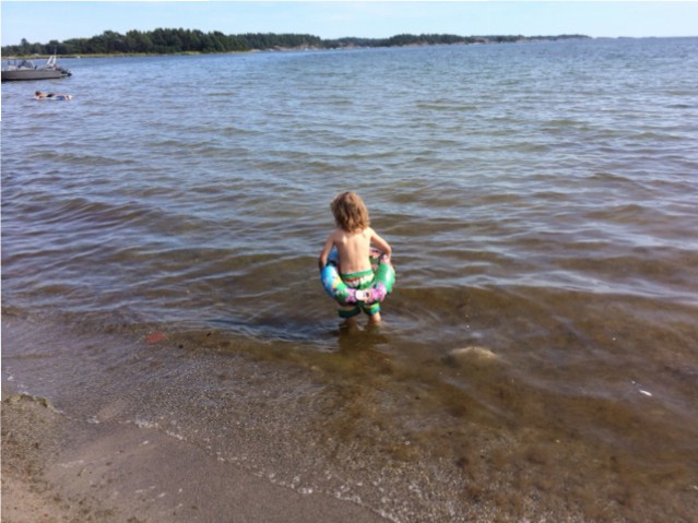Hugo badar i strandkanten på Järflotta